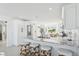 Bright kitchen features an island, white cabinets, granite countertops, stainless steel appliances, and breakfast bar at 311 22Nd St, Belleair Beach, FL 33786