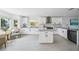 Modern kitchen with white cabinets, marble countertops, stainless steel appliances, and island at 311 22Nd St, Belleair Beach, FL 33786