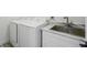 Functional laundry area with modern appliances and a utility sink set in a stylish cabinet at 311 22Nd St, Belleair Beach, FL 33786