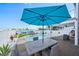 Inviting outdoor dining area with a large umbrella, overlooking a beautiful waterfront pool at 311 22Nd St, Belleair Beach, FL 33786