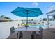 Outdoor dining area with an umbrella, with a view of the pool and waterfront at 311 22Nd St, Belleair Beach, FL 33786