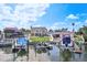 Waterfront home featuring a well maintained lawn, dock with jet skis, and outdoor seating at 311 22Nd St, Belleair Beach, FL 33786