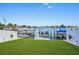 Waterfront property featuring a private boat dock with multiple boat slips and jet ski lifts on a sunny day at 311 22Nd St, Belleair Beach, FL 33786