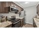 Kitchen featuring stainless steel appliances, granite countertops, and dark wood cabinets at 3325 Bayshore Blvd # A31, Tampa, FL 33629