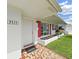 Close-up of the front entrance featuring mosaic tiles, red shutters, and a white door at 3515 100Th N Ter, Pinellas Park, FL 33782
