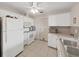 Bright kitchen features white appliances, tile flooring, and door access to the outside at 3515 100Th N Ter, Pinellas Park, FL 33782