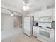 Kitchen features white appliances, tile flooring, and views to another living area at 3515 100Th N Ter, Pinellas Park, FL 33782