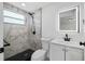Modern bathroom features illuminated mirror, marbled tile shower, and black fixtures at 3614 Vasco St, Punta Gorda, FL 33950