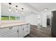 Well-lit kitchen with white cabinetry, stone countertops, and modern pendant lighting at 3614 Vasco St, Punta Gorda, FL 33950