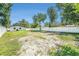 Spacious backyard offers privacy with its white fence and mature trees at 3617 E Louisiana Ave, Tampa, FL 33610