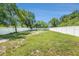 Private backyard with a white fence, mature trees, and plenty of green space at 3617 E Louisiana Ave, Tampa, FL 33610