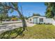 A nicely maintained white home with white rock landscaping and a bright teal door at 3617 E Louisiana Ave, Tampa, FL 33610