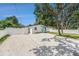A well-maintained white home with a teal door, surrounded by white gravel and a white fence at 3617 E Louisiana Ave, Tampa, FL 33610