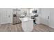 Modern kitchen features a stainless steel refrigerator, an island, and white cabinetry at 3617 E Louisiana Ave, Tampa, FL 33610