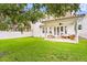 Great backyard features a covered patio and a large green lawn with a white fence at 3814 W Sevilla St, Tampa, FL 33629