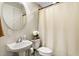 Clean bathroom features a white sink, toilet, and neutral shower curtain at 3814 W Sevilla St, Tampa, FL 33629