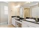 Bathroom featuring dual sinks with granite countertop and mirrors, separate shower, and soaking tub for a luxurious experience at 3814 W Sevilla St, Tampa, FL 33629
