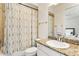 Bathroom featuring granite countertop, white vanity, and shower with floral curtain at 3814 W Sevilla St, Tampa, FL 33629