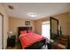 Comfortable bedroom featuring a queen-size bed with red linens, a dresser, and a window for natural light at 4015 My Lady Ln # 7, Land O Lakes, FL 34638