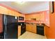 Kitchen featuring wood cabinets, black appliances, countertop seating area, and tile flooring at 4015 My Lady Ln # 7, Land O Lakes, FL 34638