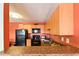 Open-concept kitchen with modern appliances, wood cabinets, and a breakfast bar for casual dining at 4015 My Lady Ln # 7, Land O Lakes, FL 34638