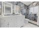 This bathroom features a double sink vanity, gray marbled tile and a glass enclosed shower at 417 Manor Blvd, Palm Harbor, FL 34683