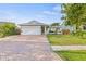 Charming single-story home featuring a brick driveway, well-manicured lawn, and a delightful garden in the front at 417 Manor Blvd, Palm Harbor, FL 34683