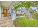Inviting front porch and beautiful garden landscaping with lush greenery providing a vibrant curb appeal at 417 Manor Blvd, Palm Harbor, FL 34683