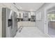 An elegant kitchen features stainless steel appliances, white cabinetry, and a door to the backyard at 417 Manor Blvd, Palm Harbor, FL 34683
