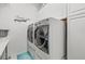 Laundry room featuring modern, front-loading washer and dryer and white cabinets at 417 Manor Blvd, Palm Harbor, FL 34683