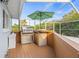 Outdoor kitchen with grill and mini refrigerator inside a screened patio at 417 Manor Blvd, Palm Harbor, FL 34683