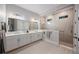 Bathroom featuring double vanities, a large mirror, and a walk-in shower at 425 4Th N Ave, Tierra Verde, FL 33715