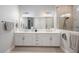 Bathroom featuring double vanities, a large mirror, and a walk-in shower at 425 4Th N Ave, Tierra Verde, FL 33715