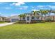 Charming home featuring mature landscaping, a gray roof, a well-manicured lawn, and a gray two-car garage at 425 4Th N Ave, Tierra Verde, FL 33715