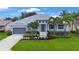 Beautiful exterior of a two-story home featuring manicured landscaping, a gray roof, and a gray two-car garage at 425 4Th N Ave, Tierra Verde, FL 33715