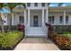 Inviting covered front porch with staircase and well-manicured landscaping at 425 4Th N Ave, Tierra Verde, FL 33715