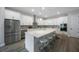 Modern kitchen with stainless steel appliances, white cabinetry, gray backsplash, and a large island with barstool seating at 425 4Th N Ave, Tierra Verde, FL 33715