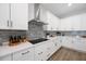 Close-up of a modern kitchen with stainless steel appliances, white cabinets, gray backsplash, and ample counter space at 425 4Th N Ave, Tierra Verde, FL 33715