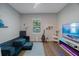 Cozy living room featuring a comfortable blue sofa and entertainment center, illuminated by natural light at 425 4Th N Ave, Tierra Verde, FL 33715