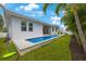 A long pool extends to the end of the house with a clean lawn, creating a beautiful outdoor space at 425 4Th N Ave, Tierra Verde, FL 33715