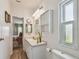 Bright bathroom with a white vanity, ample storage, and a window for natural light at 427 Pelican S Dr, Oldsmar, FL 34677