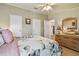Comfortable bedroom with neutral walls, floral bedding, and a large dresser at 427 Pelican S Dr, Oldsmar, FL 34677