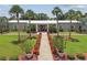 A landscaped entrance to a building featuring beautiful flowers, palms, and benches at 427 Pelican S Dr, Oldsmar, FL 34677