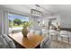 Spacious dining area with large windows overlooking the well-manicured front lawn and modern table at 4300 Maple Ne St, St Petersburg, FL 33703