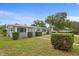 A well kept single story home is highlighted by lush, green shrubbery with palm trees under a blue sky at 4300 Maple Ne St, St Petersburg, FL 33703
