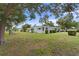 A quaint one-story home with mature trees, lush green lawn, and manicured shrubbery under a blue sky at 4300 Maple Ne St, St Petersburg, FL 33703