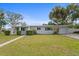 Charming single-story home featuring a manicured lawn and a lovely palm tree in the front yard at 4300 Maple Ne St, St Petersburg, FL 33703