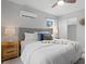 Main bedroom boasts plush bedding, wood floors, and a bedside table with lamps at 4300 Maple Ne St, St Petersburg, FL 33703
