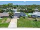 Aerial view of a well-manicured property with lawn, dark roof, and private pool at 4518 Helena Ne St, St Petersburg, FL 33703