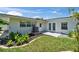 Landscaped backyard with white exterior, garden, concrete patio, and door at 4518 Helena Ne St, St Petersburg, FL 33703